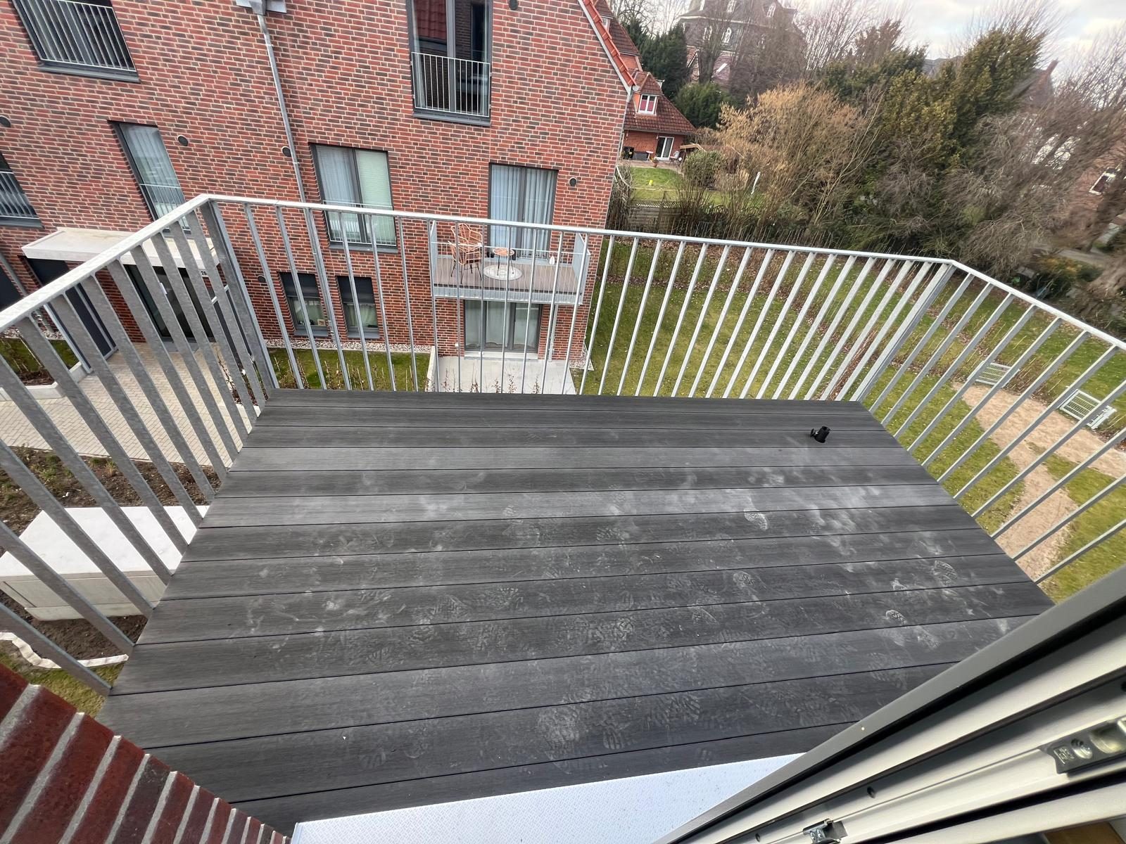 Sanierter Balkon mit neuem WPC-Belag und freier Sicht durch Hauszeit E&B